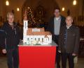 Bild: mmj
Pfarrer Wolfgang Dietz freute sich über das Engagement von Willibald Kulzer (links) und Hans Mösbauer (rechts), die eine Miniaturausgabe der Pfarrkirche im hinteren Teil des Kirchenschiffes aufstellten. Am Modell haben die Erbauer Fahnen mit den Farben der Stadt und der Kirche vor dem Eingangsportal gehisst.