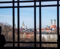 Bild: Lino Mirgeler
Ein Abgeordneter blickt aus einem Fenster des Landtags auf die Skyline von München mit der Frauenkirche.