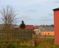 Bild: fjo
Nur zwischen der Grundschule (rechts) und dem Pfarrgarten (links) sind die beiden Windräder von der Waidhauser Ortsmitte aus zu sehen. Eine Erhöhung von bislang 80 Meter auf über das Doppelte ist beantragt.