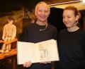 Bild: jrh
Akkordeonistin Maria Gafka (rechts) und Alexander Baginski mit dem von seiner Frau nachgemalten Bilderbuch für Tommy.