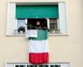 Bild: Mauro Scrobogna/LaPresse via ZUMA Press/dpa
Eine Bewohnerin Roms klatscht und singt am Fenster ihrer Wohnung. An ihrem Fenster hängt eine Landesfahne mit der Aufschrift "Grazie Italia".