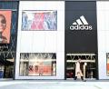 Bild: Arne Dedert
Eine Frau geht an einem Adidas-Store vorbei. Foto: Arne Dedert/dpa