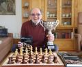 Bild: Wolfgang Steinbacher
Heinz Däubler hält zwei Dinge in Händen, übe die er sich sehr freut: den fünften Band seiner "Kniffeligen Schachaufgaben" und den Pokal für den Sieg im Seniorenturnier des Schachfestivals Bad Wörishofen.