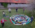 Bild: le
Im Garten des Pfarrzentrums präsentiert der Evangelische Frauenbund um Vorsitzende Christa Riedel (Dritte von links) seinen 100-Meter-Schal.