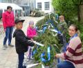 Bild: Daniela Donhauser
Drei Kindergartenkinder aus dem Marienheim schmücken mit ihren Erzieherinnen den Maibaum.