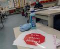 Bild: Peter Kneffel/dpa
Ein Schild mit der Aufschrift "Bitte sitzen bleiben!" liegt auf einem Tisch im Klassenraum einer vierten Klasse.