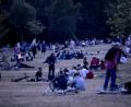 Bild: Christoph Soeder/dpa
Menschen sitzen nachts im Volkspark Hasenheide auf einer Wiese.