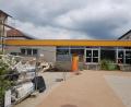Bild: gi
Das Dach der Pausenhalle der Grundschule Moosbach wird saniert. Noch nicht entscheiden wollen die Gemeinderäte über die künftige Größe der Fenster der Pausenhalle (auf dem Bild der ebenerdige Zwischenbau).