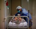 Bild: Natacha Pisarenko/AP/dpa
Eine Krankenschwester behandelt in einem Krankenhaus bei Buenos Aires einen mit Corona infizierten Covid-19-Patienten.
