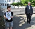 Bild: ubb
Der neunjährige Christoph hat in sechs Wochen 86 Bücher gelesen. Stolz präsentiert er seine Urkunde, Zweiter Bürgermeister Peter Gold grautliert.