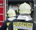 Bild: Stefan Sauer/dpa
Einsatzkräfte der Feuerwehr stehen vor einem Feuerwehrauto.