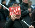 Archivbild: Paul Zinken/dpa
Ein Mann zeigt bei einer Demonstration eines rechtspopulistischen Bürgerbündnisses dem Fotografen ein Schild mit der Aufschrift „Lügenpresse“.