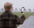 Symbolbild: Julian Stratenschulte/dpa
Ein Mann lässt in der Region Hannover auf einem Feldweg sein Smartphone nach Netzbetreibern suchen (gestellte Szene). Die Bundesregierung will den Internet- und Handyempfang in Deutschland in den kommenden zwei Jahren grundlegend verbessern.