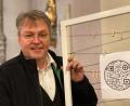 Bild: edo
Pater Adrian zeigt einen der 24 QR-Codes (rundes Symbol), die in den Kirchen der Pfarreien-Gemeinschaft zu finden sind. Für die technische Umsetzung war Schlammersdorfs zweite Bürgermeisterin Tanja Renner zuständig.