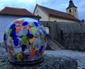 Bild: ads
So sieht er aus, der Preis: Ein Stein vom Johannisberg, umgeben von einer kunstvollen, bunten Glashülle. Im Hintergrund die Wutschdorfer Pfarrkirche St. Martin.