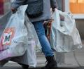Bild: Martin Schutt/dpa
Eine Frau trägt Einkaufstüten durch das Stadtzentrum.