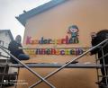 Bild: exb
Das neue Schild an der Fassade des Kindergarten Sonnenschein in Ebermannsdorf wird angebracht.