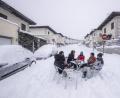 Bild: Bernat Armangue/AP/dpa
Nachbarn haben sich bei dichtem Schneefall mit Getränken in der Mitte einer Straße an einen Tisch gesetzt.