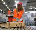 Symbolbild: Ina Fassbender/dpa
Eine Amazon-Mitarbeitern scannt ein Paket ein.