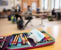 Bild: Matthias Balk/dpa
Der Ersatz-Mundschutz einer Schülerin liegt während des Unterrichts in einer vierten Klasse einer Grundschule in München auf dem Federmäppchen der Schülerin.