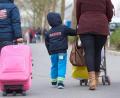 Symbolbild: Bernd Thissen/dpa
Eine Flüchtlingsfamilie mit Koffer und Kinderwagen.