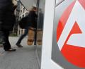Symbolbild: Patrick Seeger/dpa
Personen gehen vor dem Schild der Arbeitsagentur in Freiburg zum Eingang.
