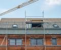 Symbolbild: Lino Mirgeler/dpa
Ein Baukran steht an einem neugebauten Haus. Auch im Birgland lagen im Gemeinderat viele Bauanträge vor.