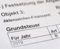 Bild: Bernd Weissbrod/dpa
Ein Bescheid über die Grundsteuer liegt auf einem Schreibtisch.