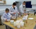 Bild: fsb
Familie Miesslinger aus Landshut und Umweltpädagogin Mack beim Vorbereiten der Erdfarben.