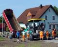 Bild: lgc
Mit schwerem Gerät bringen Arbeiter für die Erschließung des Baugebietes Süd IV Asphalt auf.
