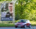 Archivbild: Daniel Karmann/dpa
"Wer hat mich hier ermordet?" steht auf einem großen Plakat mit Foto des Opfers neben dem Tatort.