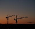 Symbolbild: Robert Michael/dpa
Kräne stehen vor dem Abendhimmel auf einer Baustelle.