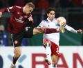 Bild: Daniel Karmann/dpa
Nürnbergs Tim Handwerker (links) kommt per Scherensprung vor Ludovit Reis (HSV) an den Ball