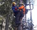 Bild: exb/Bergwacht Amberg
Auf dem Bild ist zu sehen, wie ein Bergretter, ausgerüstet mit Baumrettungsmaterial, den Übungspatienten im Kletterhochsitz für das Abseilen aus acht Metern Höhe vorbereitet.