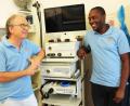 Bild: Dagmar Williamson 
Facharzt für Innere Medizin und Gastroenterologie, Michael Köllinger (links), weiht den jungen Chirurgen und „Arzt des Jahres 2020 in Uganda“, Kasalirwe Paul, in seiner Praxis in der Georgenstraße in die Geheimnisse der Endoskopie ein.