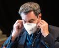 Archivbild: Armin Weigel/dpa
Ministerpräsident Markus Söder nimmt seine Maske ab.