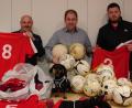 Bild: ATS Mitterteich/exb
Zeug- und Platzwart Arno Zeitler (links) sowie Trainer Florian Schaumberger (rechts) vom ATS Mitterteich waren mit Maskottchen Sam (vorne) gekommen, um die Trikots und Bälle an Kinderdorfleiter Holger Hassel zu übergeben.
