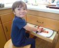 Bild: AELF/exb
Frederick schnippelt mit Eifer die Tomaten beim Kurs „Kinder an die Töpfe".