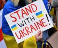 Bild: Felix Hörhager/dpa
Eine Demonstrantin steht mit einem Plakat "Stand with Ukraine! " steht bei einer Demo.