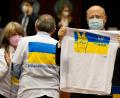 Bild: Virginia Mayo/AP/dpa
Ein Mitglied des Europäischen Parlaments hält ein T-Shirt in den Farben Blau und Gelb zur Unterstützung der Ukraine.