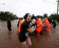 Bild: Jason O'brien/AAP/dpa
Eine Frau im australischen Lismore sucht mit Baby Schutz vor den Fluten.  Sintflutartiger Regen hat die schweren Überschwemmungen im Osten Australiens weiter verschärft.