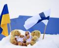 Bild: Vesa Moilanen/Lehtikuva/dpa
Fahnen der Ukraine und Finnlands in Kontiolahti neben den Weltcup-Maskottchen im Schnee.