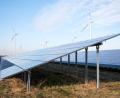 Bild: Daniel Bockwoldt/ZB/dpa
Blick auf einen Solarpark, im Hintergrund sind Windräder zu sehen.