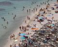 Bild: Clara Margais/dpa
Touristen genießen an einem Strand bei Puerto Portals auf Mallorca die Sonne und das Meer.