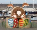 Symbolbild: Bernd Wüstneck/dpa
Eine Osterhasen-Skulptur aus Strohballen steht eingezäunt im Boddenhafen.