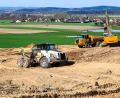 Bild: Hösamer
Große Muldenkipper und Raupen sind im Einsatz, um die Flotationssandhalde am ehemaligen Marienschacht umzulagern und zu sichern. Im Hintergrund ist Wölsendorf (Gemeinde Schwarzach) zu erkennen, das dem Flussspat-Revier seinen Namen gab.