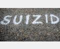 Symbolbild: Maja Hitij/dpa
Das Wort „Suizid“, auf den Boden geschrieben vor dem Brandenburger Tor in Berlin bei einer Aktion zum Welttag der Suizidprävention (10. September).