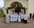 Bild: dlu
Die Erstkommunionkinder mit Pfarrer Roland Klein und den Ministranten vor der Pforte der Pfarrkirche St. Petrus und Paulus in Neukirchen.