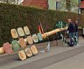 Bild: R. Kreuzer
Noch liegt der geschmückte Baum mit Schildern der Innungs- und Berufszünfte auf Holzböcken, doch er ist schon an dem Kran gebunden, der ihn in die Vorrichtung hebt.