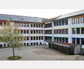 Bild: Thomas Dobler
Der A-Bau (links) und der B-Bau (rechts) der Schule sind sanierungstechnisch schon abgeschlossen. Im Untergeschoss des B-Baus wurde eine Mensa (dunkler Vorbau rechts) einschließlich Küche und Nebenräume untergebracht.